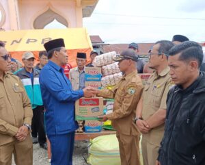 Anggota DPRK Aceh Tengah, Ilyas Sadikin saat menyerahkan bantuan bagi korban kebakaran Jagong Jeget. Foto / Romadani